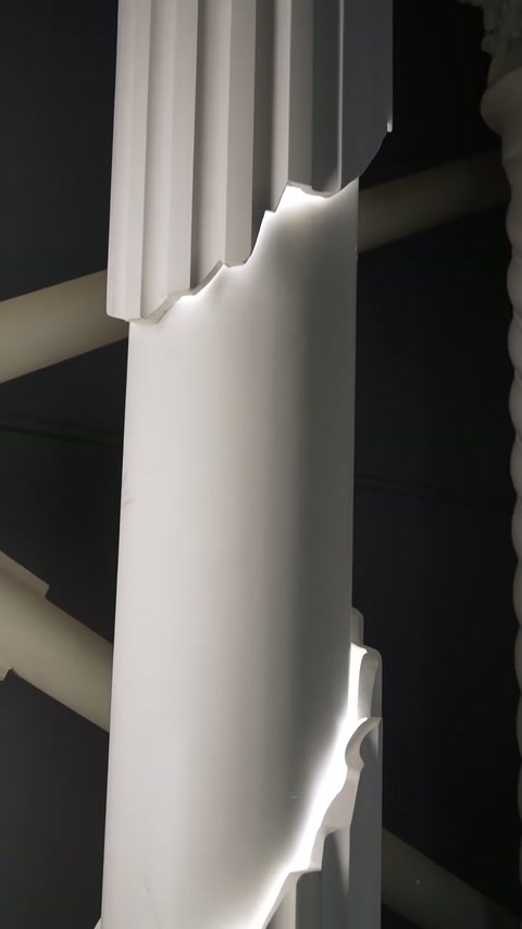Inserția verticală iluminată separă segmentele profilate ale coloanei decorative.