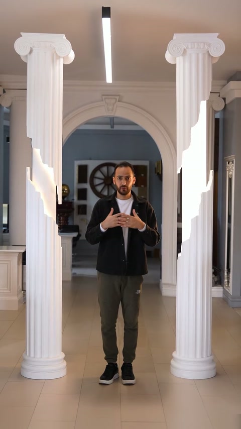 Prezentatorul este încadrat de două coloane finisate și arcada showroomului.