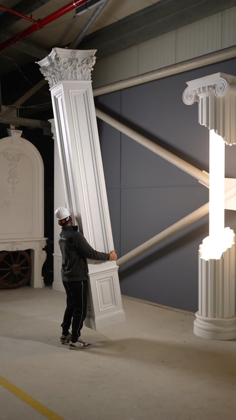 Un pilastru decorativ înalt este înclinat pentru demonstrarea greutății reduse.