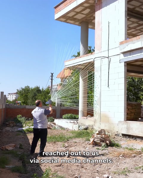 Tehnician scanează fațada cu scanerul 3D, linii laser vizibile pe perete