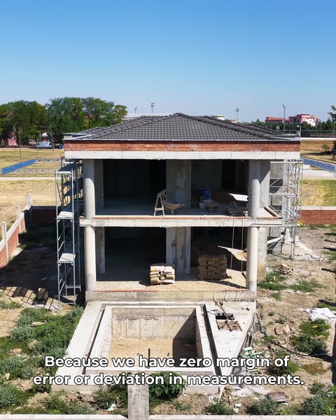 Vedere aeriană a vilei cu schelă, structura brută vizibilă pe fațadă
