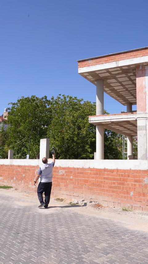 Scanarea continuă sub balconul deschis al construcției.