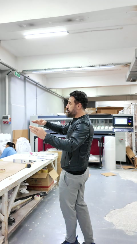 Explicarea etapelor de ambalare lângă utilajul automatizat din atelier.