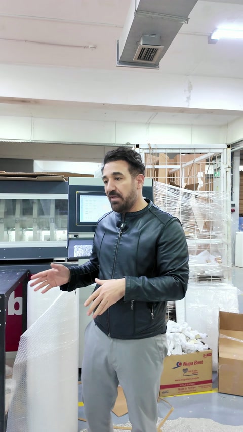 Operatorul explică setarea cutiilor lângă mașina de ambalare.