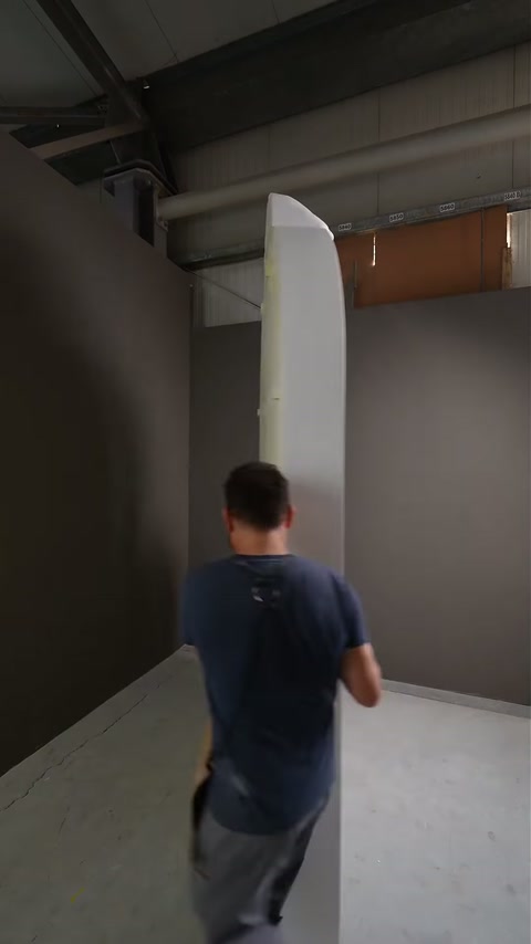Videoclipul prezintă panoul decorativ alb transportat vertical pentru asamblare.