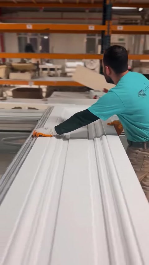 Operatorul aliniază un panou canelat în timpul procesului de fabricație.