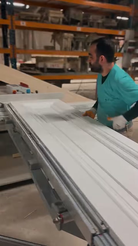 Piesa decorativă profilată înaintează pe masa de lucru din atelier.
