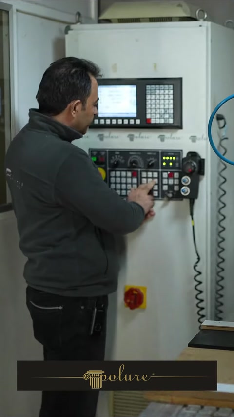 Operatorul configurează utilajul CNC pentru prelucrarea componentelor decorative.