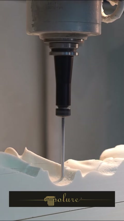 Utilajul CNC frezează un profil curbat într-un bloc alb.