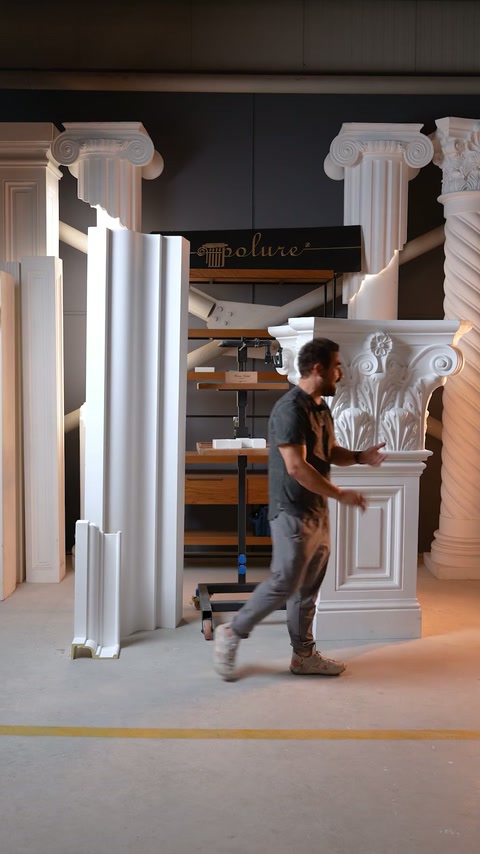 Muncitorul aduce un capitel decorativ lângă pilastrul pregătit în atelier