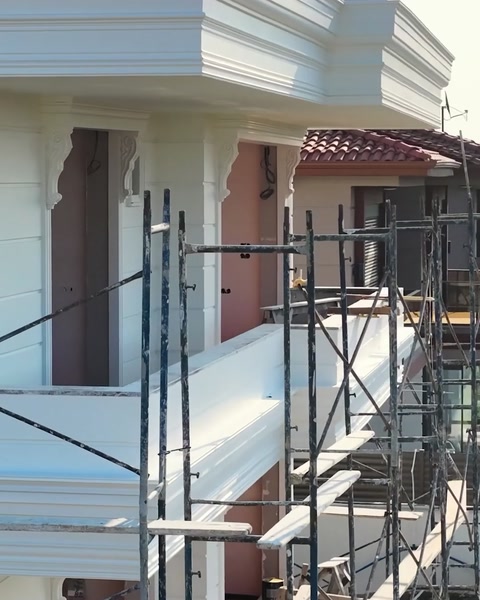 Schelă pe fațadă cu șir de cornișe deja montate