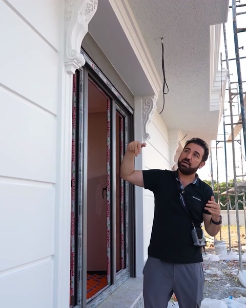 Bărbat arată coloana ornamentală de la intrarea vilei