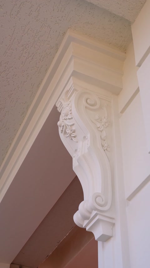 Detaliu apropiat al consolei decorative cu motive vegetale sculptate