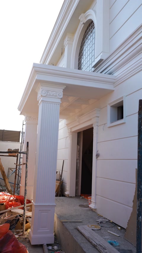 Intrarea vilei încadrată de coloane înalte și profile decorative