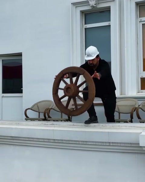 Muncitor cu cască ridică roată decorativă din poliuretan pe balcon