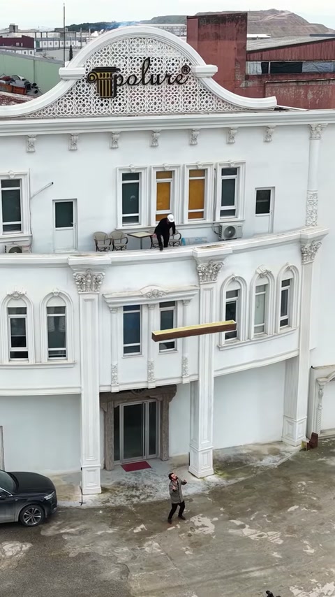 Videoclipul prezintă grinzi decorative rustice montate la intrarea unei clădiri.