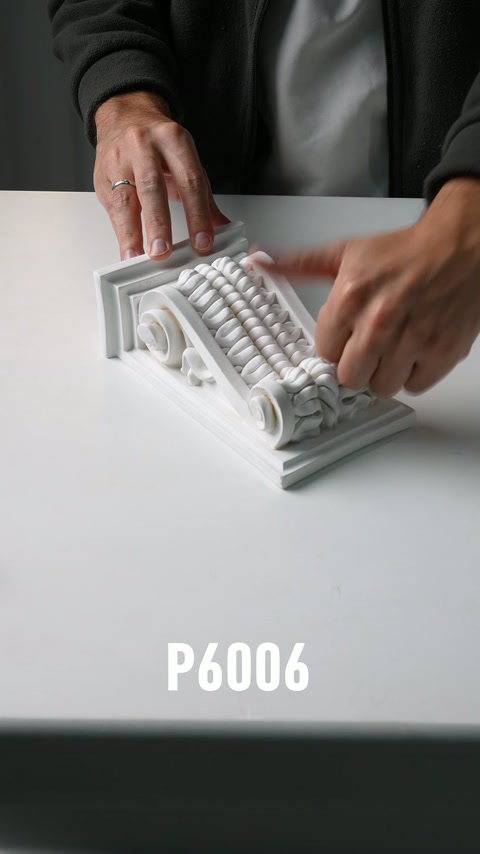 Element decorativ clasic cu volută laterală, apăsat ușor între mâini