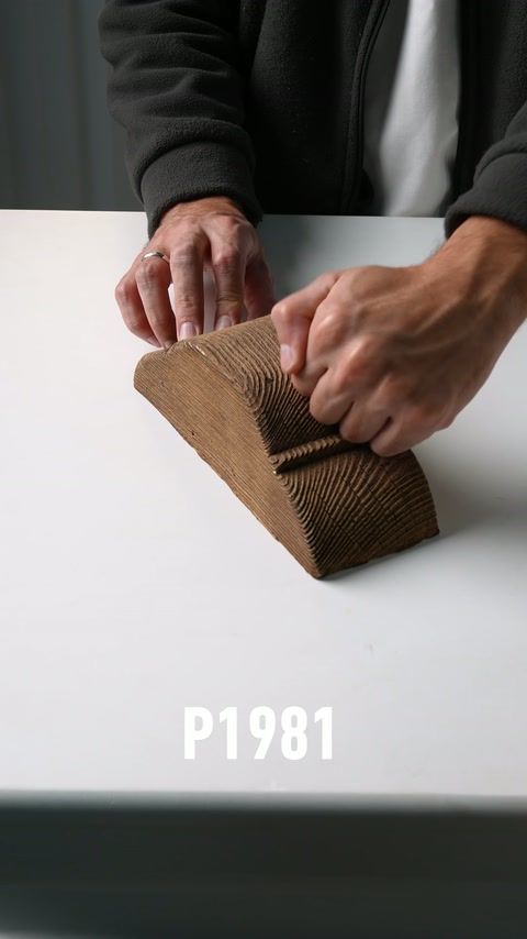 Piesă decorativă maro cu textură lemnoasă, testată prin apăsare laterală