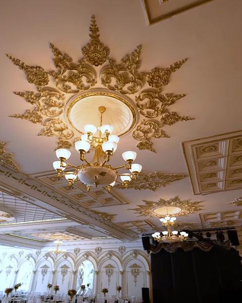 Rozetă de tavan cu candelabru deasupra scenei decorate cu voal
