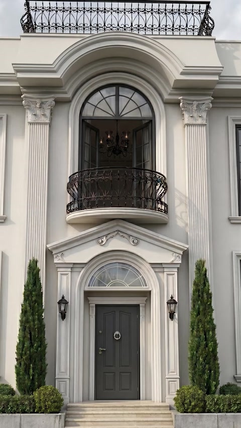 Intrare elegantă cu ancadramente arcuite, coloane și fronton decorativ