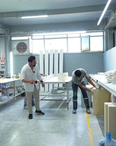 Doi bărbați pregătesc o placă mare în atelier