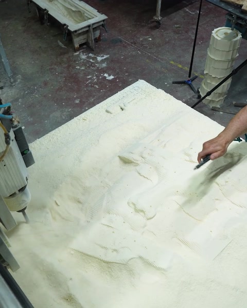 Muncitor finisează manual reliefu sculptat cu o unealtă