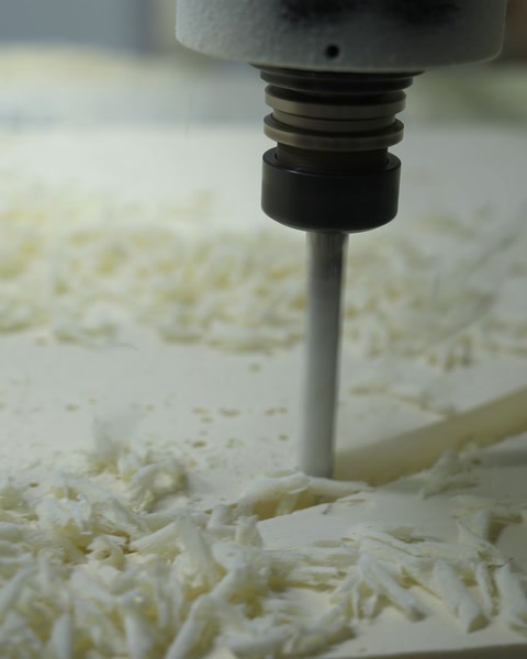 Freza CNC prelucrează o matriță, cu așchii de material.