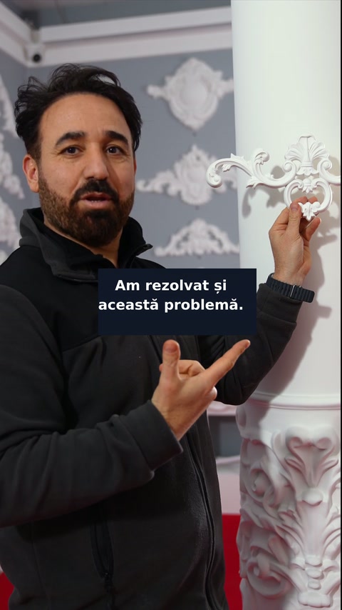 Decoratorul ține piesa rigidă lângă coloana rotundă pentru comparație.