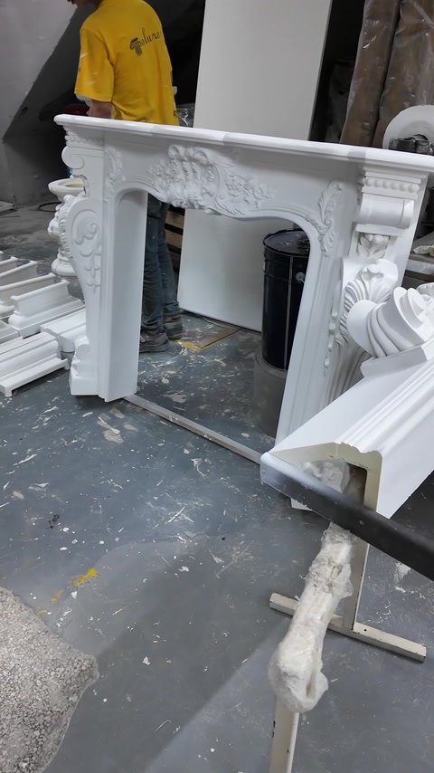 Șemineul decorativ finalizat prezintă coloane, volute și cornișă ornamentată.