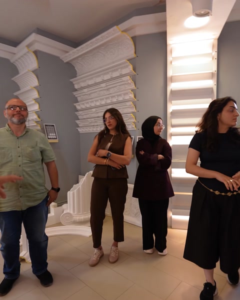Vizitatori privesc un perete cu corniceuri și profile decorative din poliuretan