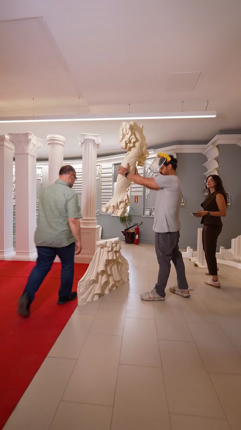 Doi bărbați montează un relief sculptural de mireasă pe coloană