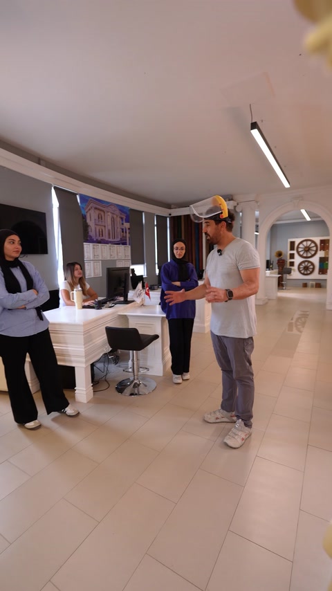 Muncitor cu cască discută cu echipa lângă birourile din showroom