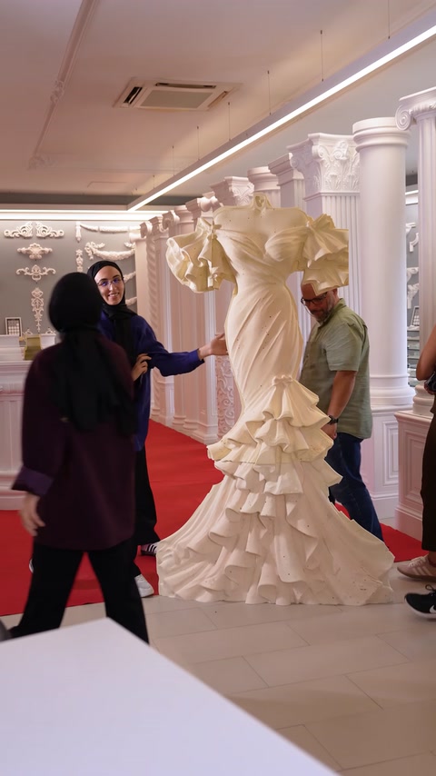 Grup de persoane trece pe covorul roșu lângă relieful sculptat