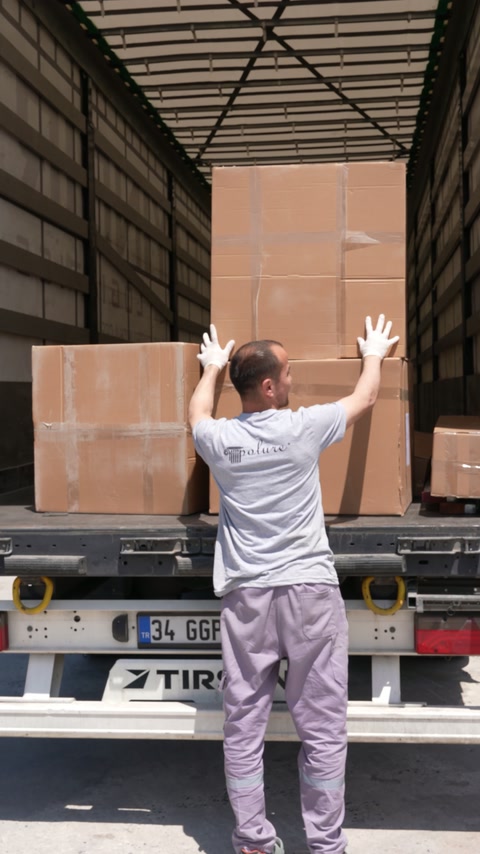 Pachetele voluminoase sunt descărcate din camion pentru livrare.